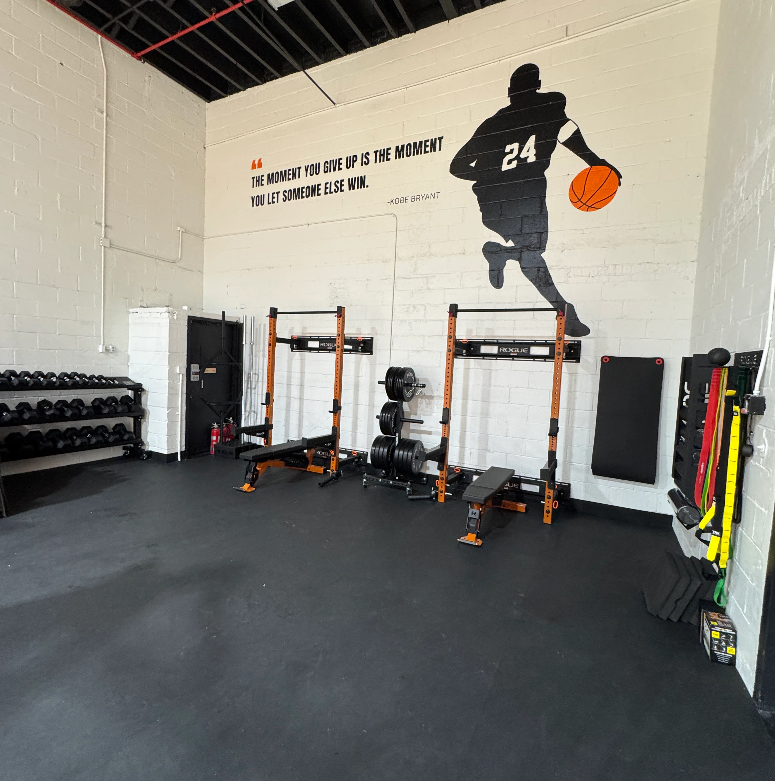 Train Klub Fort Greene weight area with squat racks and dumbbells